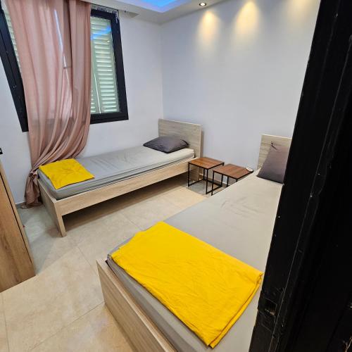 une chambre avec deux lits et une fenêtre dans l'établissement Nourhanne, à Marseille