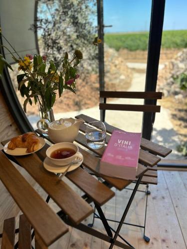 a table with a cup of coffee and a book at Masseria Li Reni in Manduria