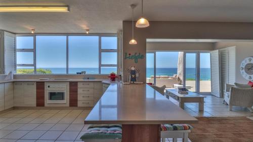a large kitchen with a view of the ocean at House Susan Pardew Hersham in Great Brak River
