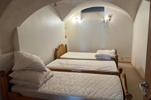 - 2 lits jumeaux dans une petite chambre avec une arche dans l'établissement T2 apartment with parking, à La Salle Les Alpes