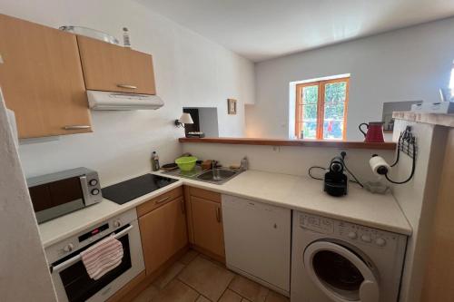 une petite cuisine avec un évier et une machine à laver dans l'établissement T2 apartment with parking, à La Salle Les Alpes