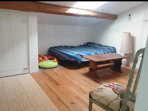 une chambre avec un lit, une table et une chaise dans l'établissement Maison de famille, à Montséret