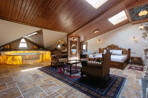 a bedroom with a bed and a living room at Kapadokya Hill Hotel & Spa (12+) in Nevsehir