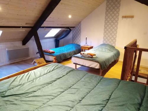 a attic bedroom with two beds and a table at Maison de montagne, vallée d'Ossau in Bielle