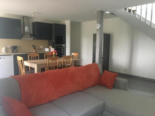 un salon avec un canapé et une cuisine dans l'établissement Charmante maison aux portes de Rennes, à Mordelles