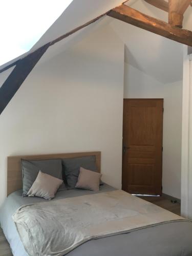 Ce lit se trouve dans un dortoir doté d'une porte en bois. dans l'établissement Charmante maison aux portes de Rennes, à Mordelles