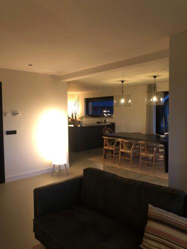 a living room with a couch and a dining room at Smithoes in Groot-Agelo