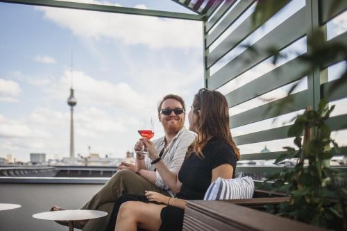 a man and woman sitting on a bench with a glass of wine at The Circus Hotel in Berlin