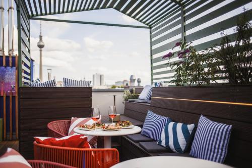 a balcony with a table and chairs with food and drinks at The Circus Hotel in Berlin