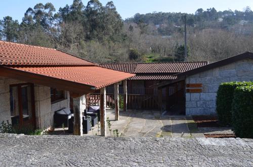 a house with a red roof and a patio at Rilhadas Casas de Campo in Fafe