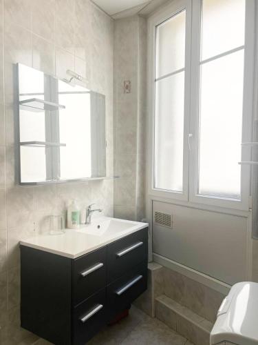 une salle de bain avec un lavabo et un miroir dans l'établissement Spacieux appartement climatisé centre Nice, à Nice