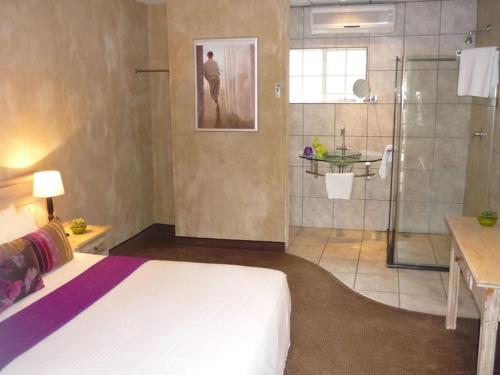 a large bathroom with a bed and a shower at At SILVER PALMS in Tzaneen