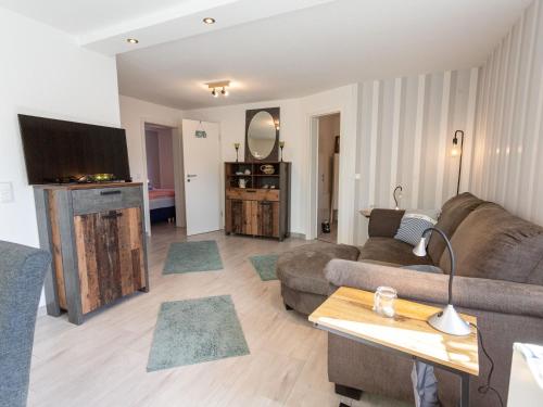 a living room with a couch and a tv at Strand Haus in Loissin