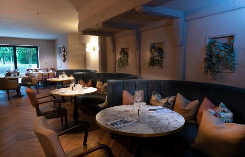 a restaurant with tables and couches and tables and chairs at Hatherley Manor Hotel & Spa in Gloucester