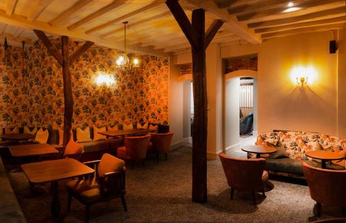 a restaurant with tables and chairs and a couch at Hatherley Manor Hotel & Spa in Gloucester