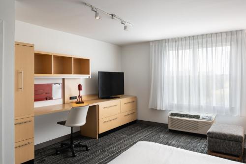 a room with a desk with a television and a bed at TownePlace Suites by Marriott Wareham Buzzards Bay in Wareham