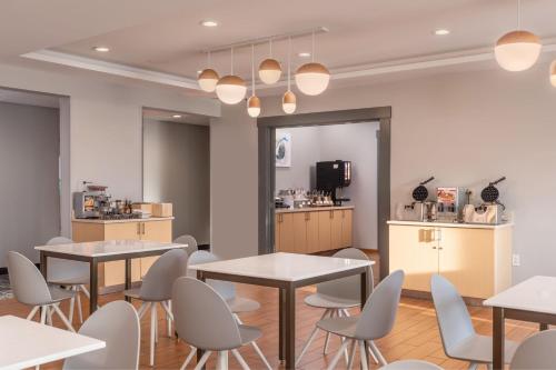 a restaurant with tables and chairs and a kitchen at TownePlace Suites by Marriott Wareham Buzzards Bay in Wareham