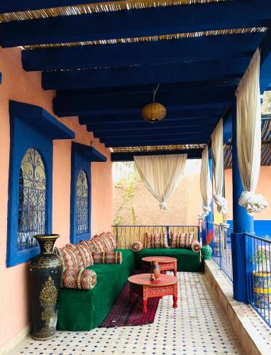 a living room with a green couch and a table at villa Oasis Rouge Sable in Marrakech