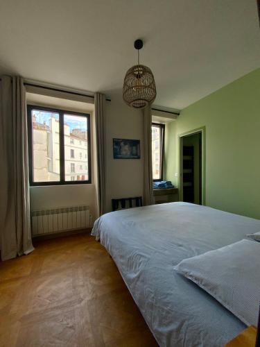 une chambre avec un grand lit et une grande fenêtre dans l'établissement Buffon, à Paris