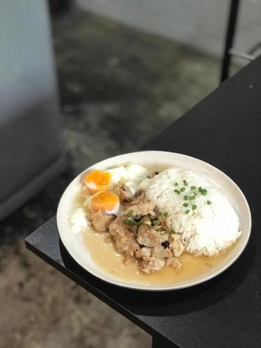 a plate of food with eggs and rice on a table at Siam Plug In Hostel in Bangkok