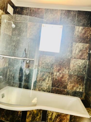 a bathroom with a bath tub and a window at Chapman Guesthouse in Pelham