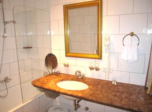 a bathroom with a sink and a shower and a mirror at Gasthof Hotel Doktorwirt in Salzburg
