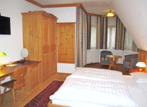 a bedroom with a bed and a desk and a table at Gasthof Hotel Doktorwirt in Salzburg