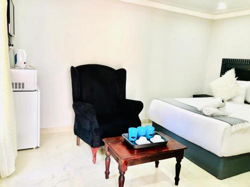 a room with a bed and a chair and a table at Chapman Guesthouse in Pelham