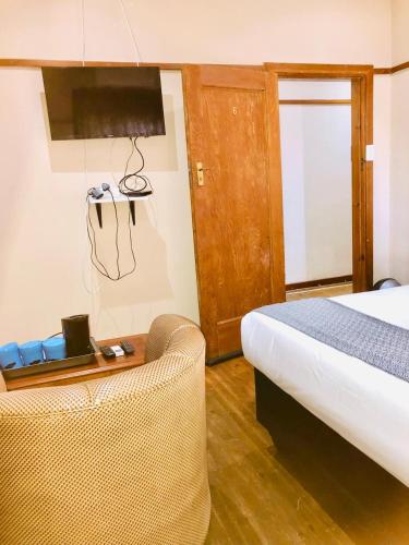 a bedroom with a bed and a chair and a table at Chapman Guesthouse in Pelham