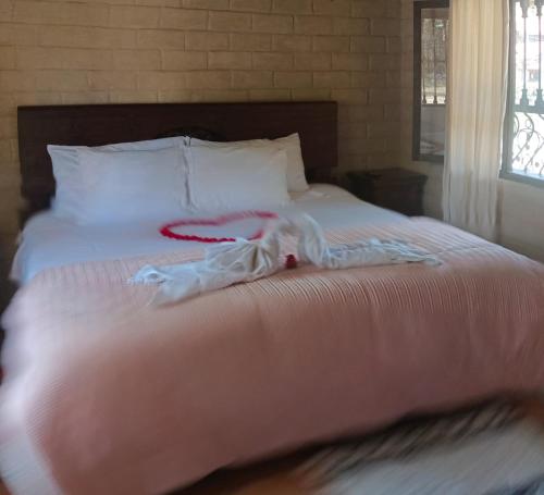 a bed with white sheets and white pillows at Hospedaje Villa Eucalyptus in Nobsa