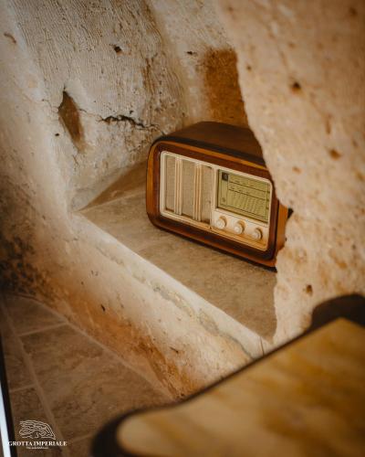 an old radio sitting on a concrete floor at Grotta Imperiale in Palagianello