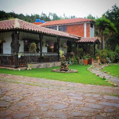 a house with a fence and a yard at Hospedaje Villa Eucalyptus in Nobsa