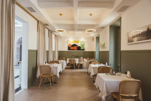 a dining room with white tables and chairs at Casa del Médico Hotel Boutique in Alcázar de San Juan