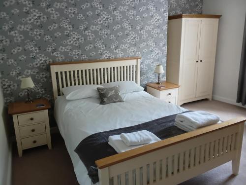 a bedroom with a bed with two night stands and two lamps at Foresters Guest House Ltd in Crook