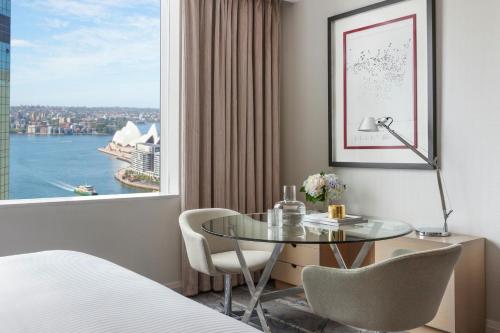 a hotel room with a table and a large window at Sydney Harbour Marriott Hotel at Circular Quay in Sydney