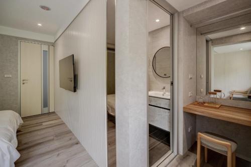 una camera da letto con bagno dotato di lavandino e specchio di Yong Li Hotel a Gukeng