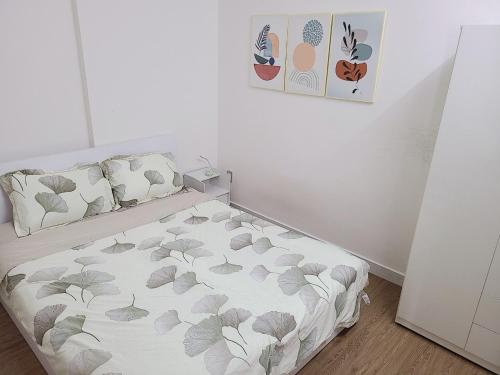 a small bedroom with a bed with leaves on it at Cozy Apartment 2BR Hacom Phan Rang in Kinh Dinh