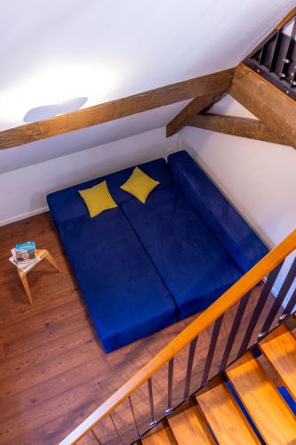 a large blue bed in a room with a staircase at schlossmühle - lean luxury boutique hotel in Glottertal