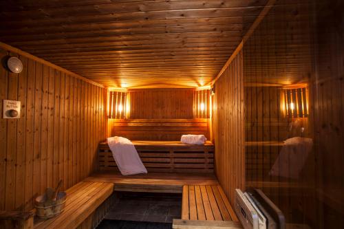 a wooden sauna with a bench and towels in it at The Old Government House Hotel & Spa in St Peter Port
