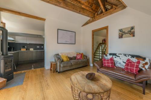 un salon avec un canapé et une table dans l'établissement Chalet Whitmoore - Argentière - Happy Rentals, à Chamonix-Mont-Blanc