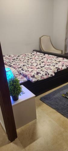 a bedroom with a bed and a table with a potted plant at Home Away Apartment in Abu Dhabi