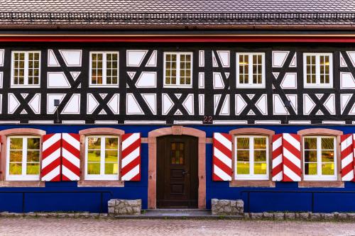 a blue and white building with a red and white flag at schlossmühle - lean luxury boutique hotel in Glottertal