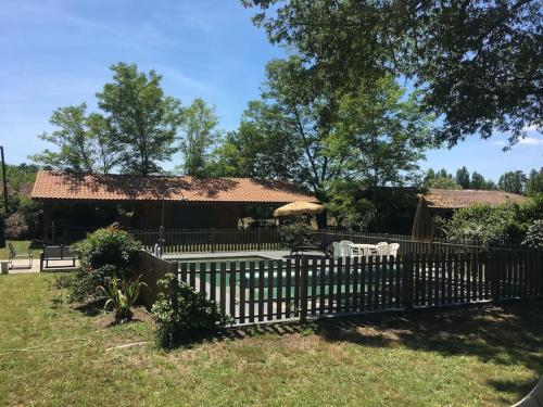 une clôture en bois devant une maison dans l'établissement Maison typique en lisière de forêt au calme, à Moustey
