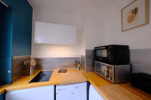 une cuisine avec un comptoir avec un micro-ondes dans l'établissement Rouen Hyper centre - Magnifique studio, à Rouen