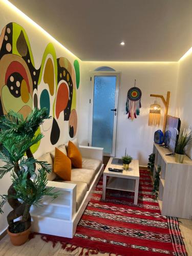 a living room with a couch and a painting on the wall at Art Riad Au Bord De La Mer in El Jadida