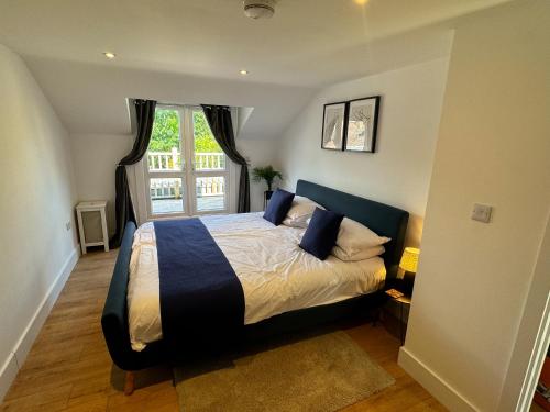 a bedroom with a king sized bed with a window at New! Central Penthouse, King Size Bed & Balconies in Maidstone