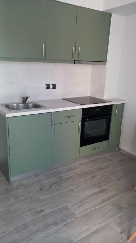 a kitchen with a sink and a microwave at Jasmine Apartments in Lefkada Town