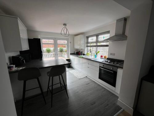 a kitchen with white cabinets and a black counter top at Cozyleigh in Southend-on-Sea