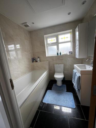 a bathroom with a tub and a toilet and a sink at Cozyleigh in Southend-on-Sea