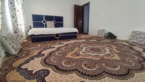 a bedroom with a bed and a large rug at Mountain Majesty in Khor